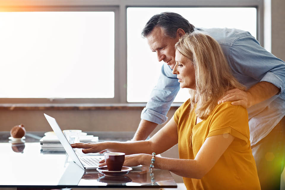 A couple looking at a laptop screen.