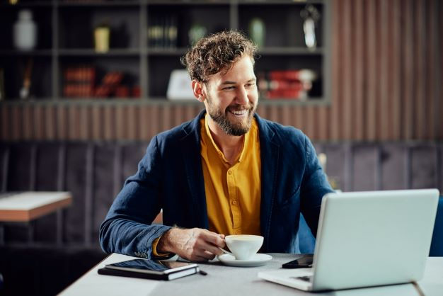 A person smiling at their laptop.