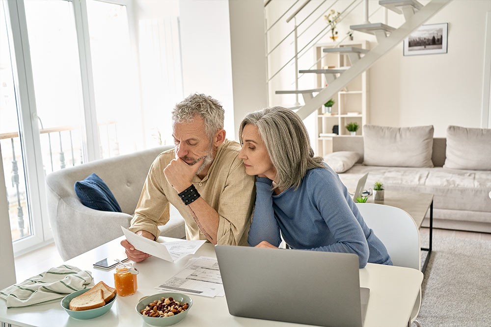 An elderly couple looking over a letter.